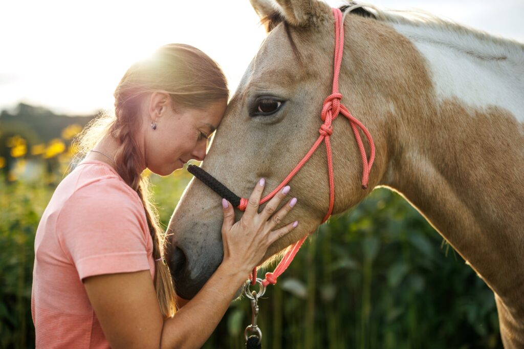 Smiling woman bonding with her horse